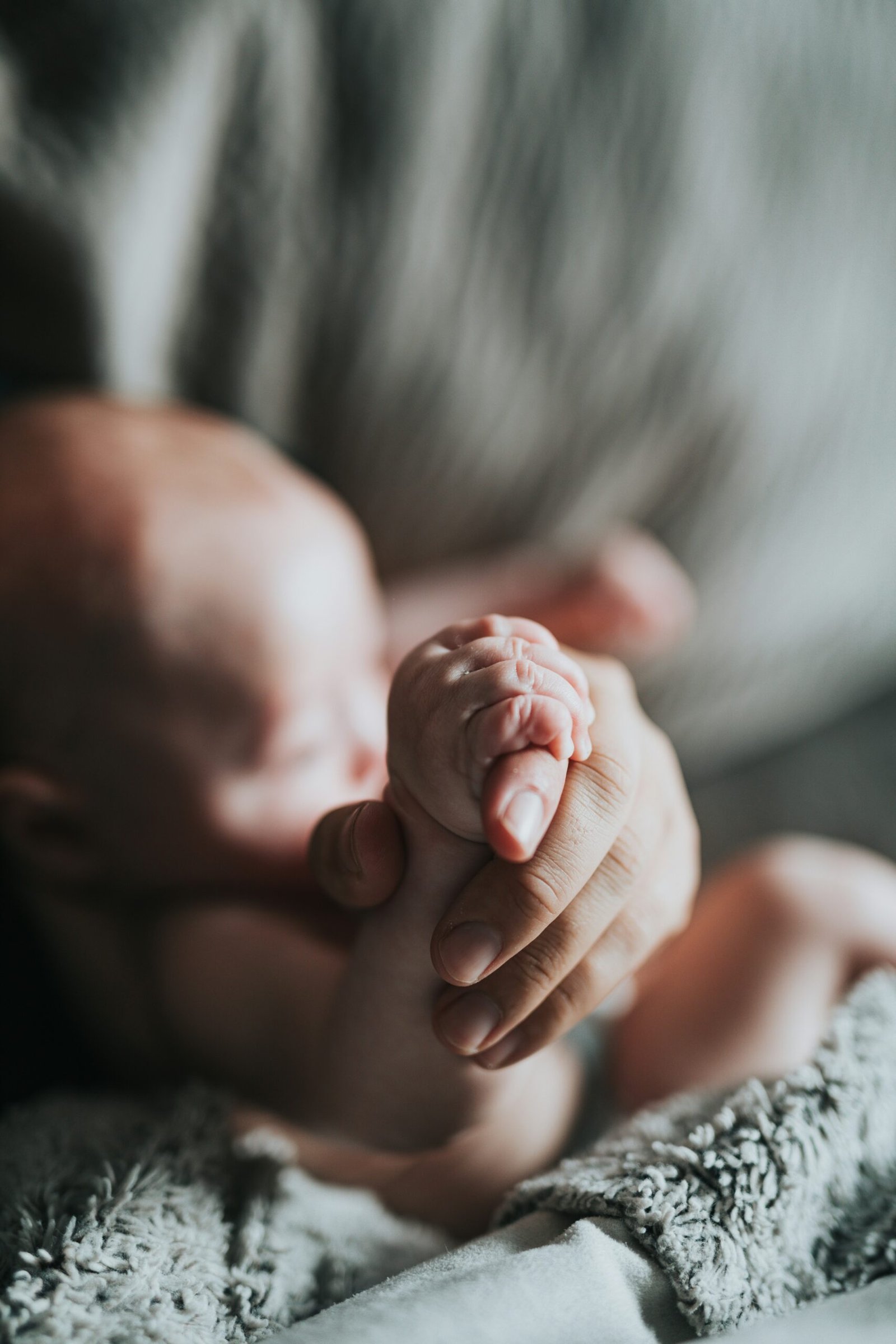 Newborn baby gently holding mother's hand, symbolizing the deep bond and love between mother and child during pregnancy and childbirth.